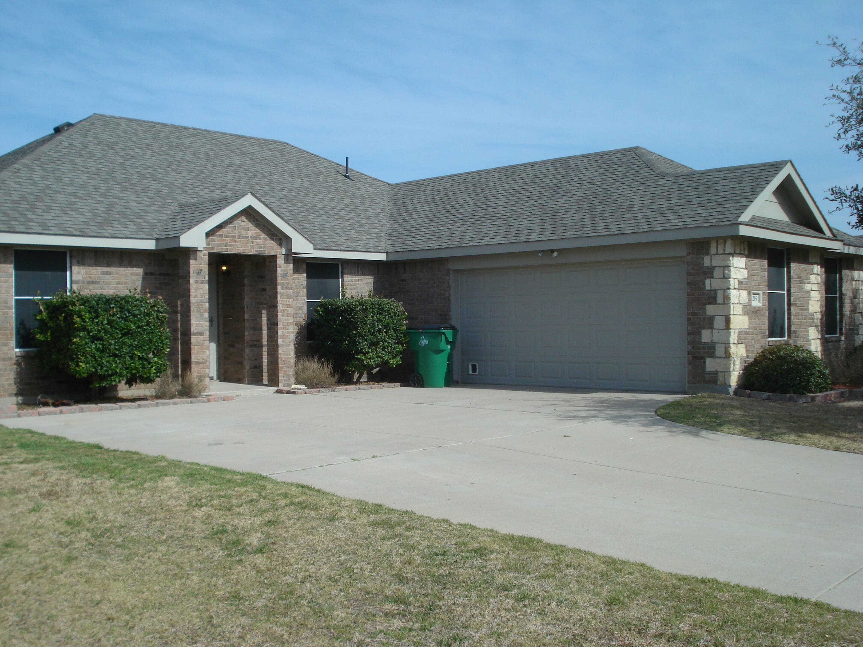 Single-story suburban house with a two-car garage and stone accents.