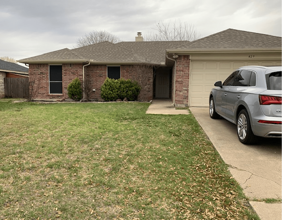 Single-story brick house with a front lawn and driveway.