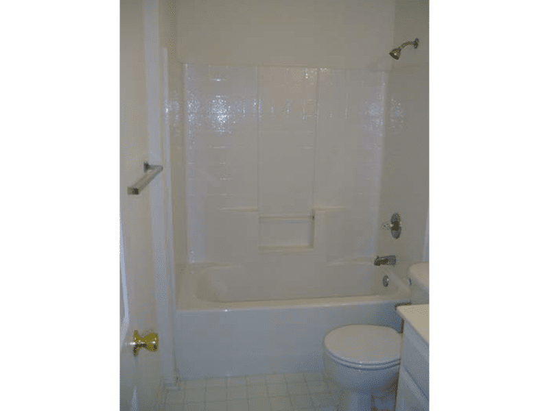 Clean white bathroom with bathtub, toilet, and sink.