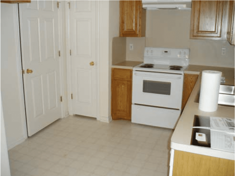A clean kitchen with white appliances and wooden cabinets.