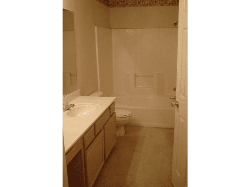 A clean bathroom with a bathtub and vanity.